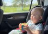 Viaggi lunghi in auto con bambini piccoli: come gestire fame, orari e tappe neonato seduto sul seggiolino in auto