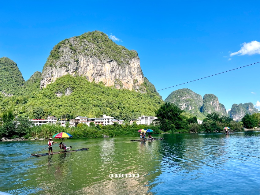 Zattera di bambù tradizionale che scivola sul fiume Yulong a Yangshuo circondata dalle montagne cinesi