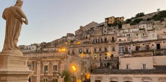 Modica: l’arte di perdersi tra le geometrie verticali del Barocco e il sapore del cioccolato Veduta panoramica di Modica, con la stratificazione delle case barocche costruite sui pendii delle colline siciliane.