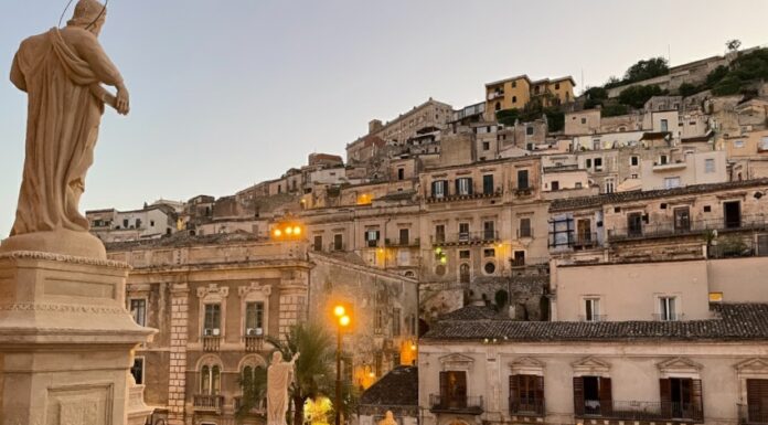Modica: l’arte di perdersi tra le geometrie verticali del Barocco e il sapore del cioccolato Veduta panoramica di Modica, con la stratificazione delle case barocche costruite sui pendii delle colline siciliane.