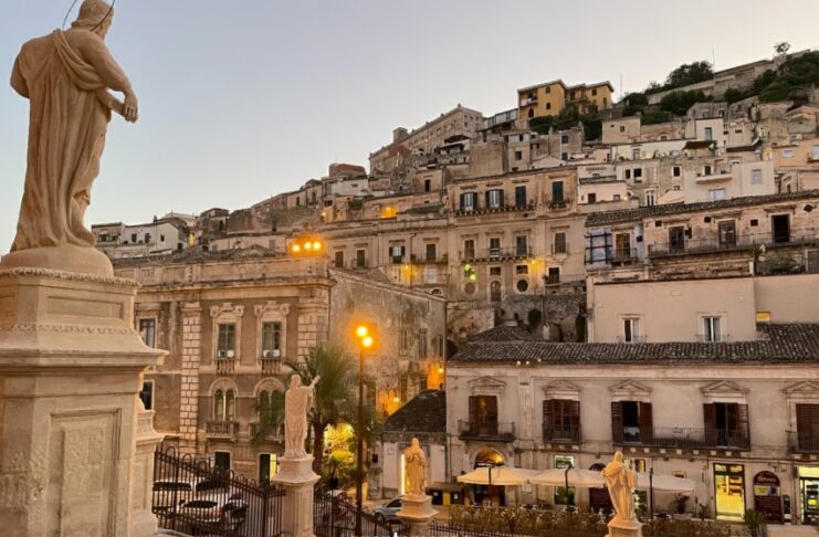 Modica: l’arte di perdersi tra le geometrie verticali del Barocco e il sapore del cioccolato Veduta panoramica di Modica, con la stratificazione delle case barocche costruite sui pendii delle colline siciliane.